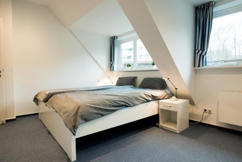 弗伦斯堡fewo1846 - Baltic Lodge - komfortable Maisonettewohnung mit 3 Schlafzimmern, Balkon und Blick auf die Marina Sonwik的卧室配有白色的床和2扇窗户。
