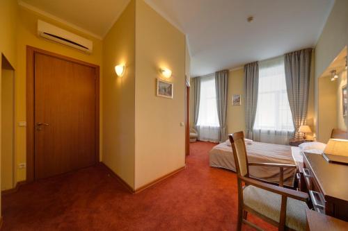 圣彼得堡Solo Isaac Square的配有一张床和一张书桌的酒店客房