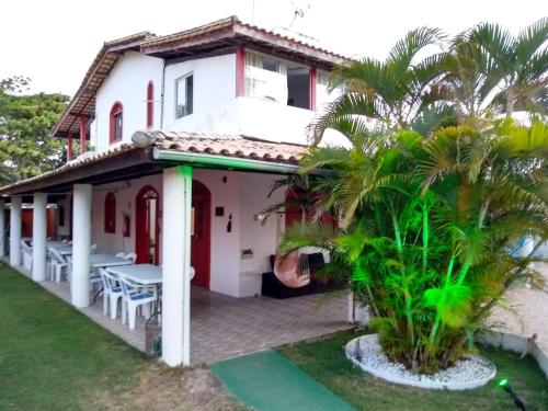 伊塔齐米林Pousada Caribe itacimirim的一座带庭院和棕榈树的房子