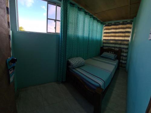 圣安德烈斯Casa Hostel San Andres的窗户客房内的小床