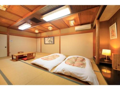 富士宫市Fujinomiya Green Hotel - Vacation STAY 19035v的一间设有床铺和桌子的房间