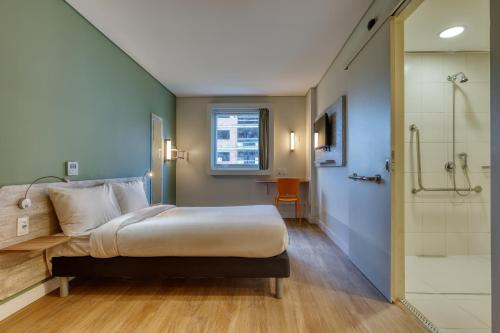 贝洛奥里藏特ibis budget BH Savassi的一间卧室设有一张床和一个步入式淋浴间。