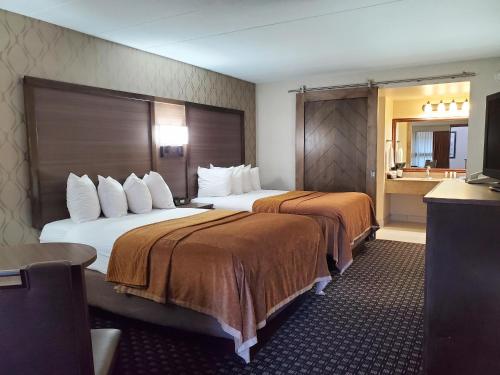 沃特敦Ramkota Hotel Watertown的酒店客房带两张床和一间浴室