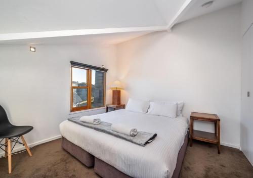 丁诺高原Triggerplant 4的卧室配有一张大白色床和窗户