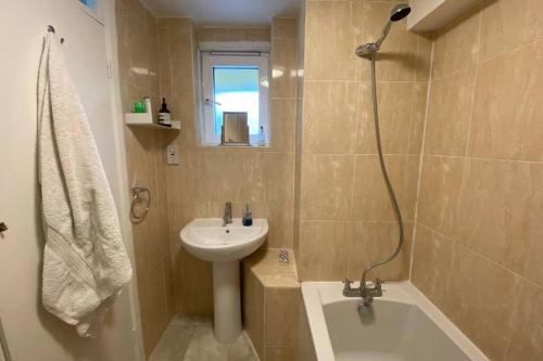伦敦Two Bedroom Garden Flat in Zone 2 London的浴室配有盥洗盆、卫生间、浴缸和盥洗盆。
