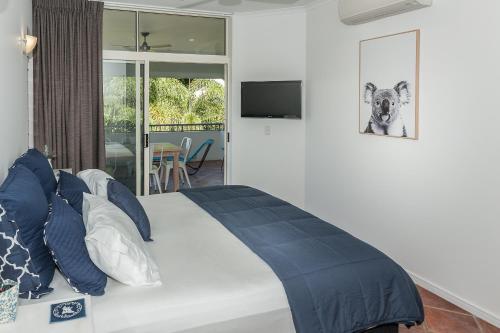 棕榈湾棕榈湾绿洲酒店的一间卧室配有一张带蓝色枕头的大床