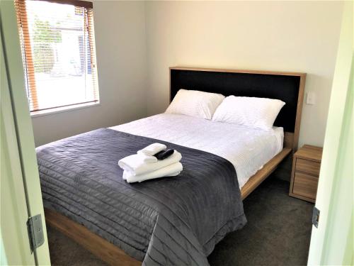 汉密尔顿Robyn's Retreat的一间卧室配有一张床,上面有两条毛巾