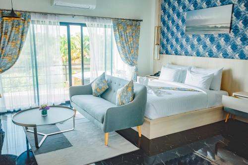 尖竹汶Phuengluang Riverside Hotel Chanthaburi的一间卧室配有一张床、一把椅子和一张桌子