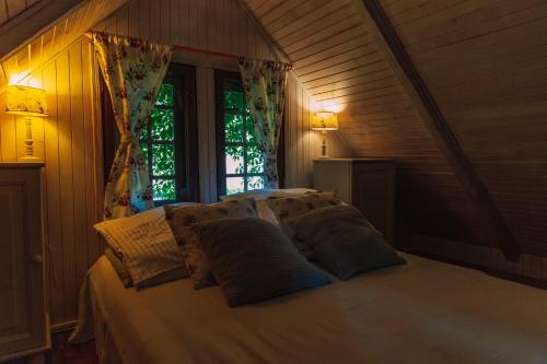 萨希诺Domki Victoria的卧室配有带枕头的床铺和窗户。