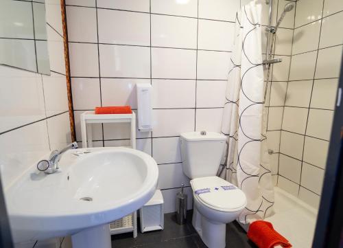 格拉纳达伊特尼尔旅馆的白色的浴室设有水槽和卫生间。