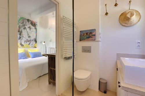 圣特罗佩Le Bastidon de PAMPELONNE的浴室设有床、卫生间和水槽。