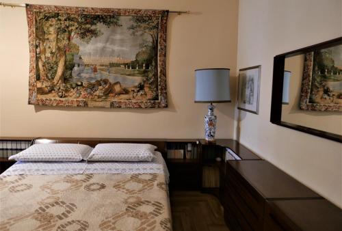 罗马La Tana di Sofia的卧室配有一张床,墙上挂有绘画作品