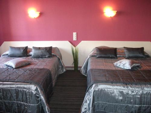 加普米什莱酒店的红色墙壁客房的两张床