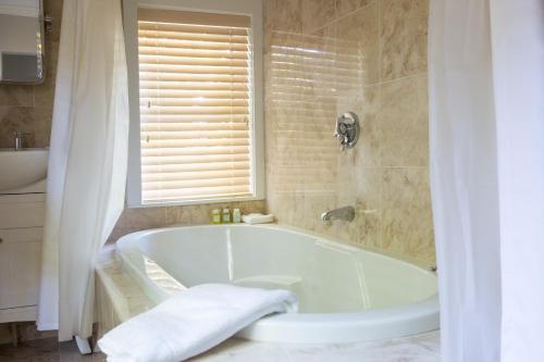 楠塔基特Hotel Pippa的带窗户的浴室内的白色浴缸