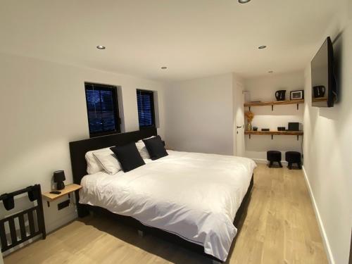 达默Damse Paveljoentje comfort en uitzicht in Damme的卧室设有一张白色大床和两个窗户。