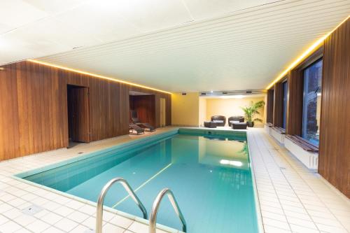 马里恩黑德Montana Landhotel Gummersbach-Nord的一座带游泳池的大楼内的大型游泳池