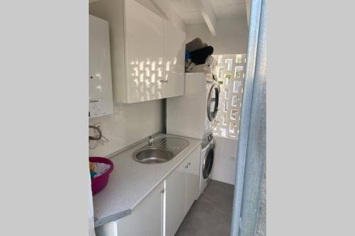 阿尔库迪亚港Amazing house close to the beach的一个带水槽和洗衣机的小厨房