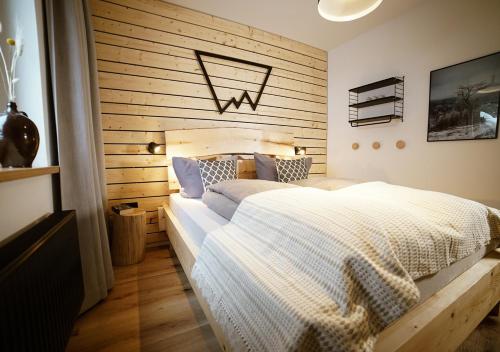 奥泊维森塔尔Chalet Hans的一间卧室设有一张床和木墙
