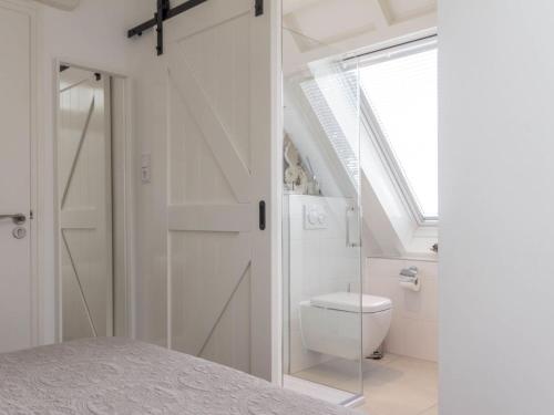 WieringerwaardVakantiewoningen Prelude & Etude的白色的浴室设有卫生间和窗户。