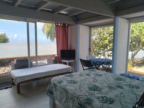 莫雷阿Bungalow blue lagon waterfront的一间卧室配有一张床,享有海景