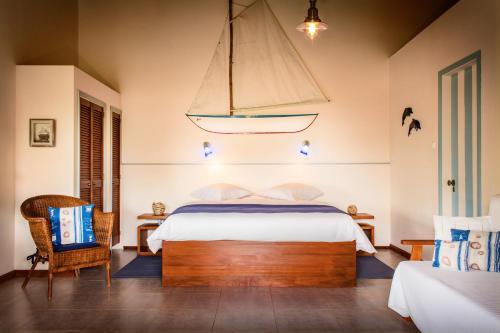 PiedadeO Zimbreiro的卧室配有一张床,墙上挂着帆船