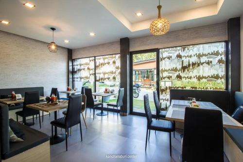 北碧Makan Resort的餐厅设有桌椅和窗户。