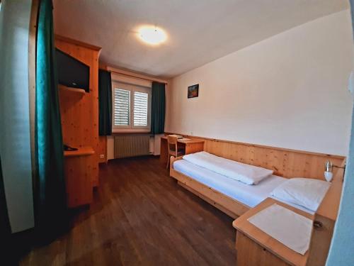 瓦尔道拉波尔巴切酒店的小房间设有一张床和一张书桌