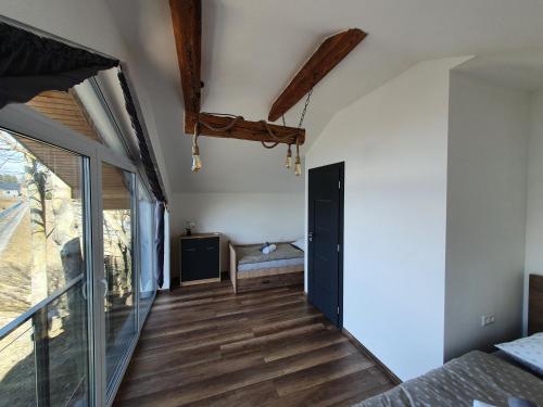 MlynčekyChatka Panorama的卧室铺有木地板,设有滑动玻璃门。