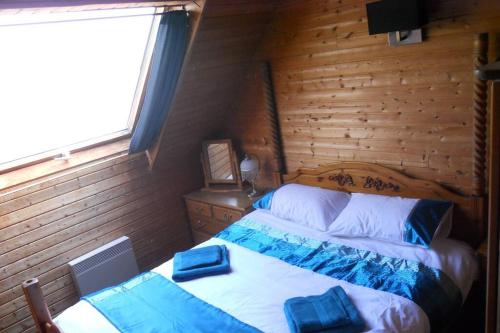 Saint-Manvieu-Bocage3 Bedroom Lodge over looking Lake Dathee & Golf Course的木制客房内的一间卧室配有两张床