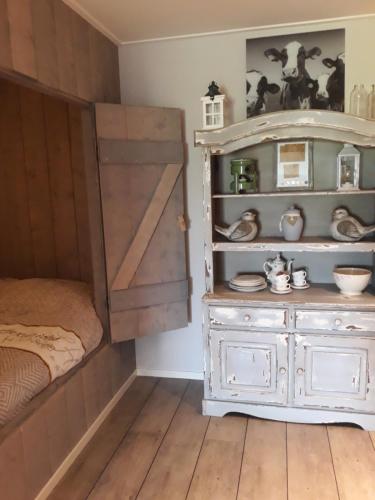 霍尔沃德De Bedstee的一间卧室设有木门和梳妆台
