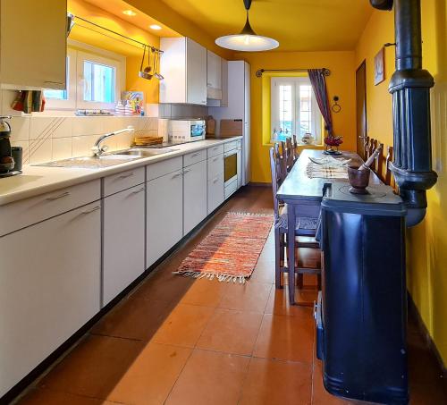 Sornico拉德贡达度假屋的一间厨房,配有白色的橱柜和蓝色的岛屿