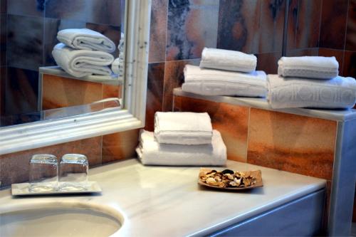 普拉亚布兰卡Villas Coral Deluxe的浴室配有盥洗盆、镜子和毛巾