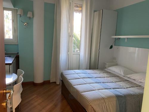 罗马Luna Rossa Roma Guest House的一间卧室配有一张床、一张桌子和一个窗户。
