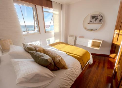拉科鲁尼亚Apartamento Paseo Marítimo的一间卧室设有两张床和窗户。