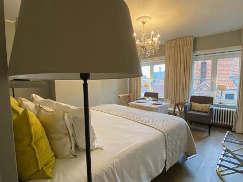 布鲁日阿莱格里亚酒店的一间卧室配有一张床,里面装有灯