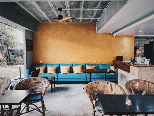 清迈Lamphu House Chiang Mai - SHA Extra Plus Certified的一间配备有蓝色沙发及桌椅的客房