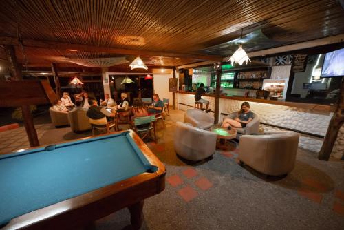 阿约拉港Hotel Las Ninfas的酒吧里一张台球桌,人们坐在椅子上