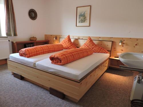 米明沃诺费尔膳食公寓的一张带橙色枕头和盥洗盆的床