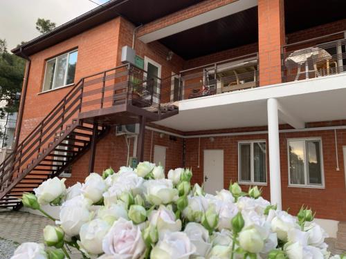 格连吉克Гостевой дом Нинель的一堆房子前面的白玫瑰