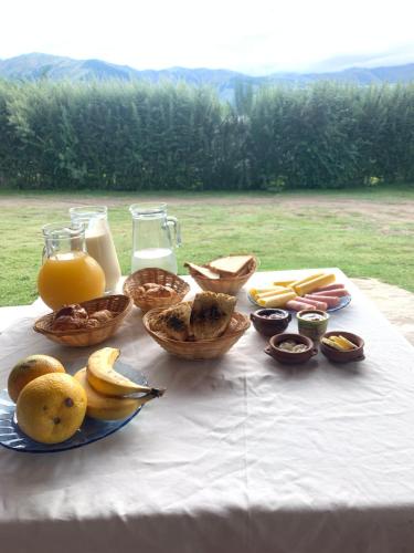 塔菲德尔瓦勒Posada La Sofia的一张桌子,上面放着一篮水果和橙汁