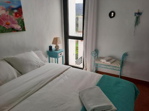 萨阿拉德洛斯阿图内斯AIRUNNES Atico duplex Zahara primera linea的卧室设有一张白色大床和一扇窗户。