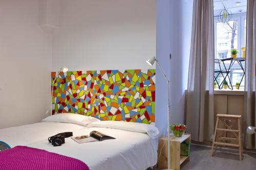 毕尔巴鄂毕尔巴鄂霹雳旅舍的一间卧室配有一张带色彩缤纷床头板的床