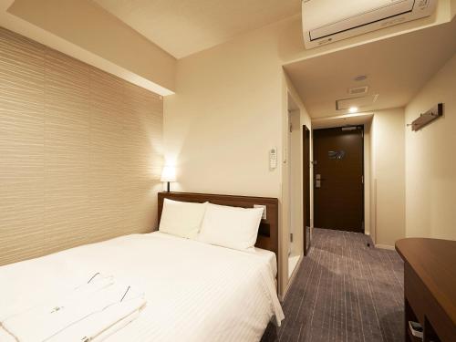 东京东京六本木苏铁草莓酒店的酒店客房,配有白色床单