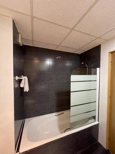 巴达霍斯康德杜酒店的设有带浴缸和淋浴的浴室。
