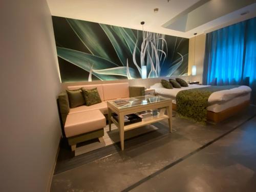 姬路ルトゥール姫路 Retur HIMEJI 男塾ホテルグループ的一间卧室配有一张床、一张沙发和一张桌子