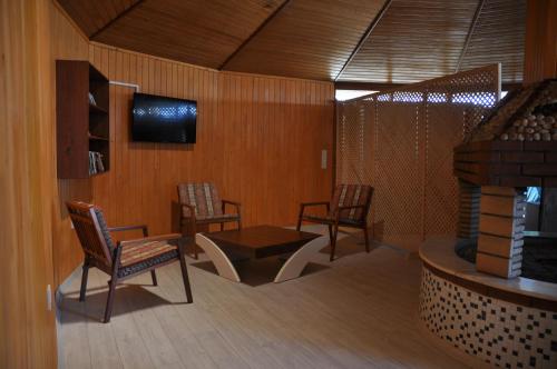 契拉勒阿卡迪亚酒店的一间带椅子和桌子的房间以及一台电视