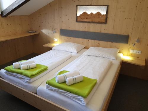 拉姆绍达赫斯坦Berghotel Türlwand的配有绿色靠垫的木制客房内的两张床