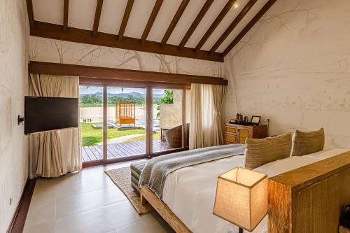 Meghauli梅格郝丽谢莱奇旺国家公园 - 泰及野生动物园山林小屋的一间卧室设有一张床和一个滑动玻璃门