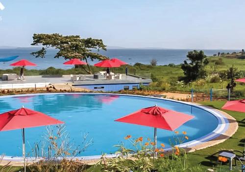 KigoAquarius Kigo Resort的一个带红色遮阳伞的游泳池,并享有海景
