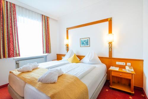 巴特霍夫加施泰因Hotel Germania Gastein - ganzjährig inklusive Alpentherme Gastein & Sommersaison inklusive Gasteiner Bergbahnen的酒店客房,设有两张床和镜子